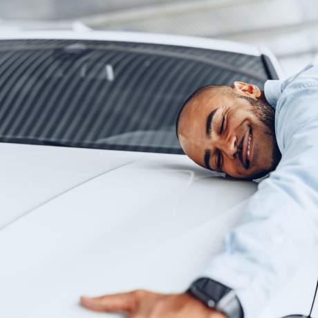 Man hugging his car